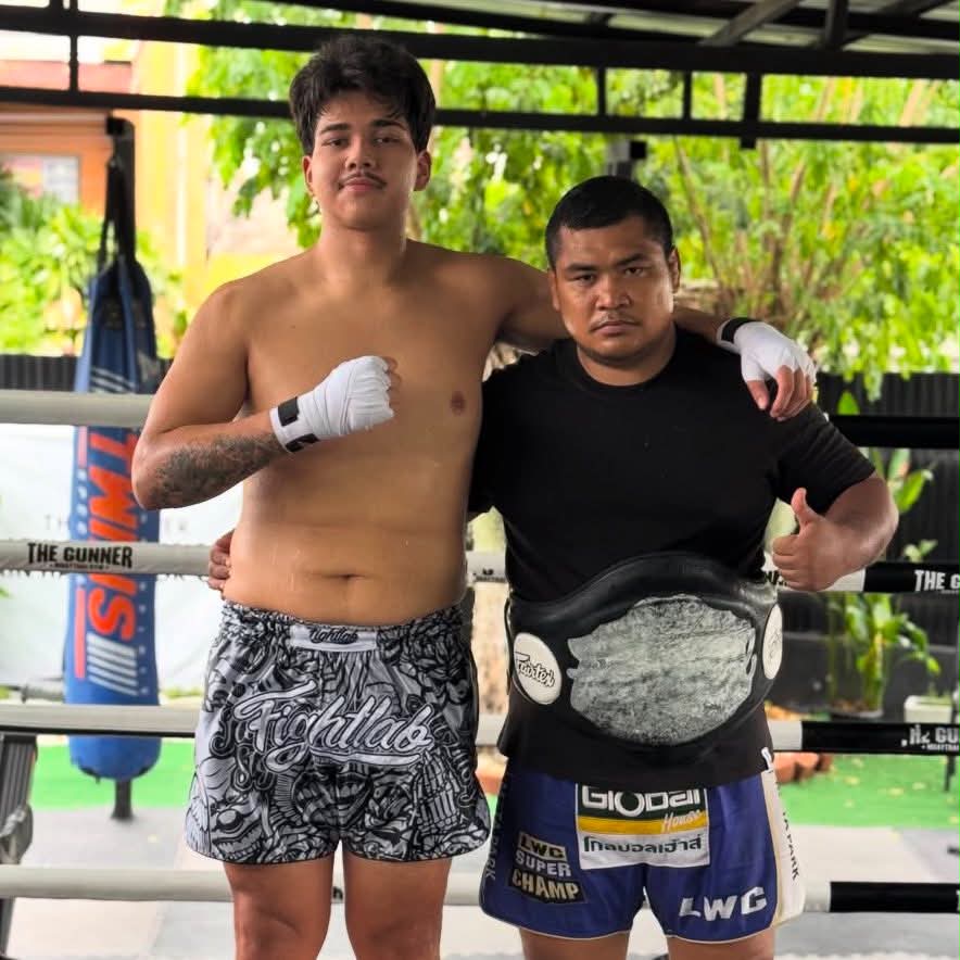 ครูเอฟกับนักมวยยืนอยู่บนเวทีมวยของ The Gunner Muay Thai Gym